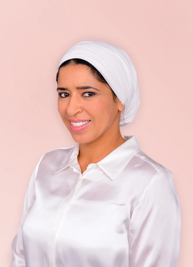 Portrait Asma Dana en plan poitrine, sur fond rosé